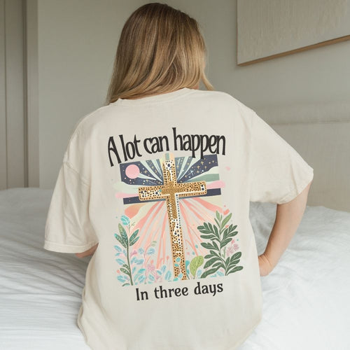 Person wearing a t-shirt with a cross design and text on the back