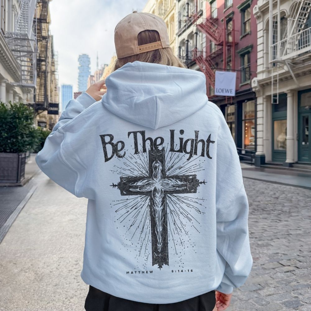 Light blue Christian hoodie with Be The Light cross design