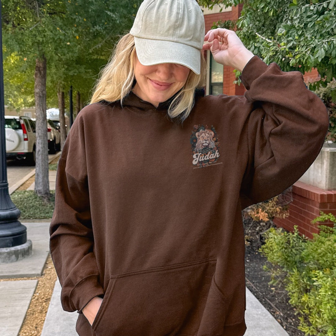 Front view of brown hoodie featuring Lion of Judah artwork with floral details and scripture inspired text
