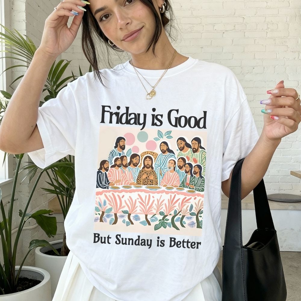 Person wearing a white t-shirt with a graphic and text 'Friday is Good But Sunday is Better' in an indoor setting.