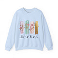 Light blue sweatshirt with floral design and 'He is Risen' text on a white background