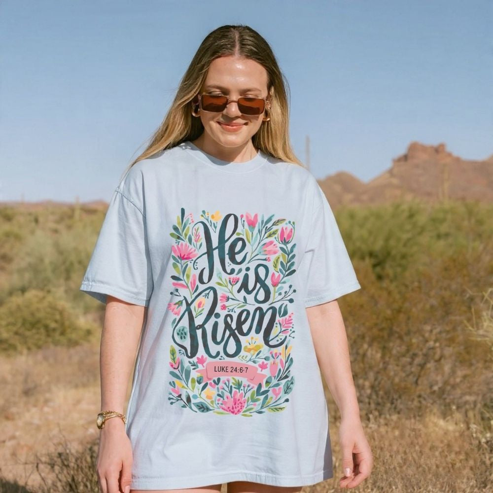 Woman wearing a 'He is Risen' t-shirt in a desert setting