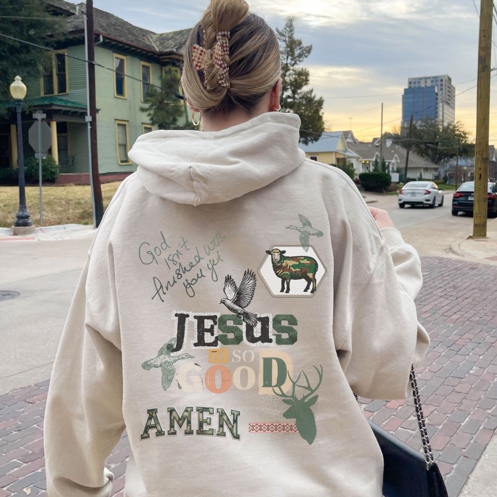 Person wearing a black t-shirt with a graphic design of a sheep and text, standing outdoors.