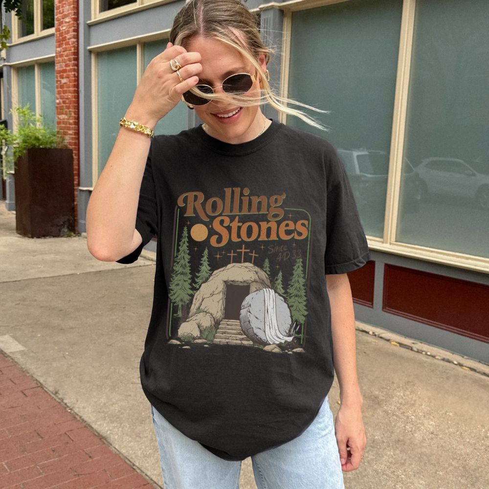 Person wearing a black 'Rolling Stones' t-shirt on a city street.