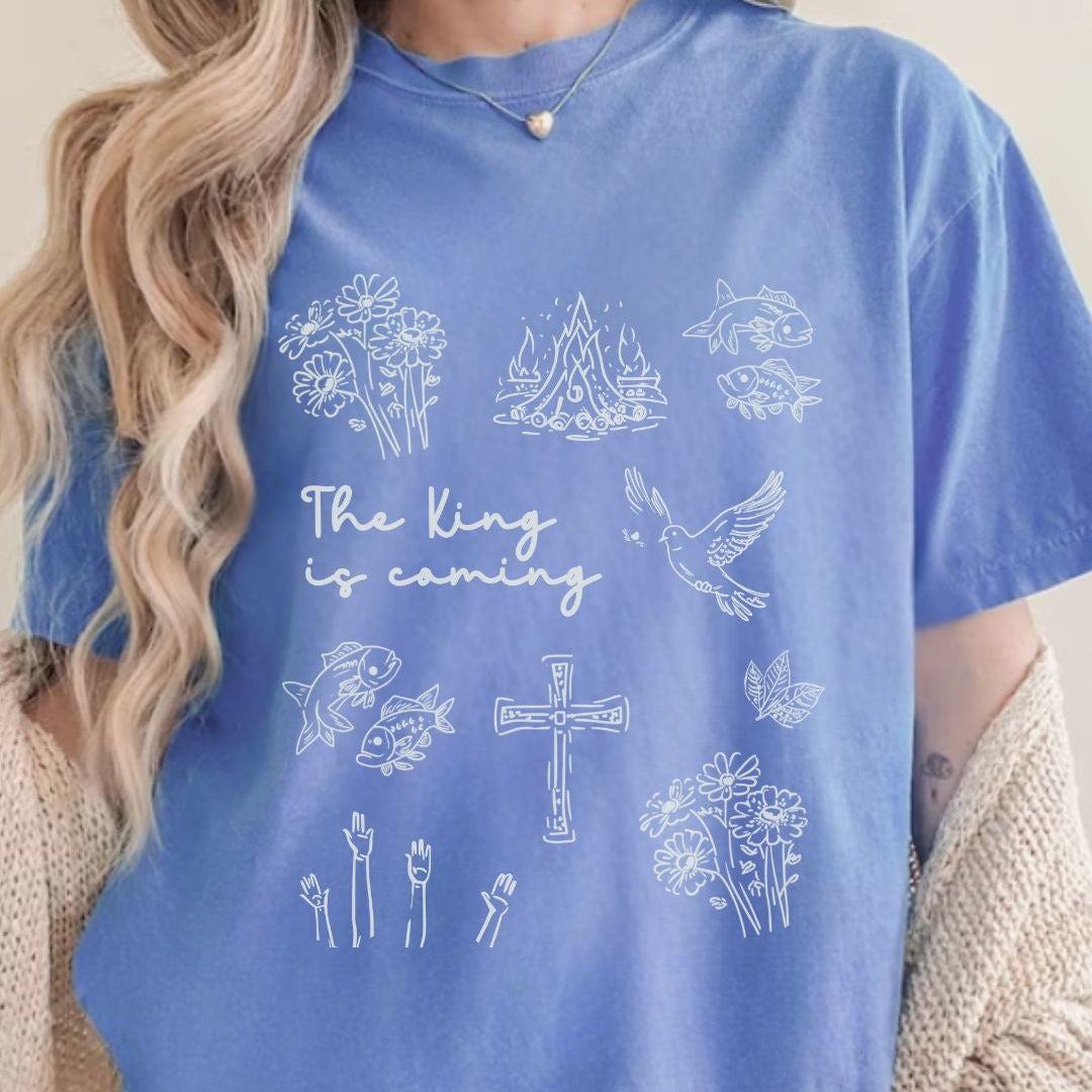 Blue faith inspired t-shirt featuring Christian symbols and the phrase The King is coming inspired by Revelation 22:12