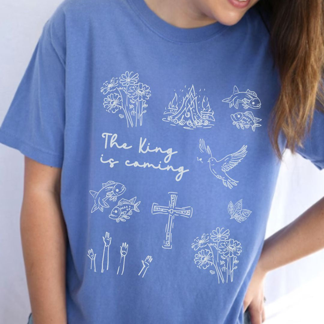 Blue faith inspired t-shirt featuring Christian symbols and the phrase The King is coming inspired by Revelation 22:12