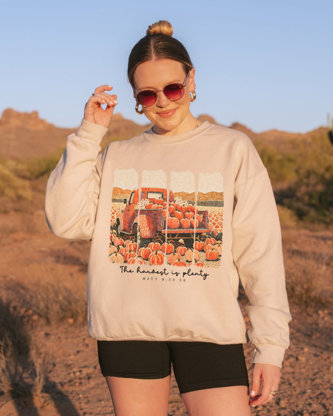 Woman wearing The Harvest Is Plenty Christian sweatshirt in desert