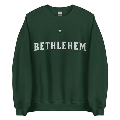 Woman wearing dark green Bethlehem Christian Christmas sweater with simple star design.