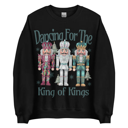 Woman wearing Dancing for the King of Kings Christian Christmas sweater with three colorful nutcracker figures.