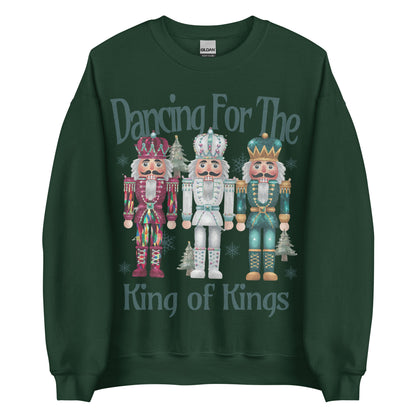 Woman wearing Dancing for the King of Kings Christian Christmas sweater with three colorful nutcracker figures.
