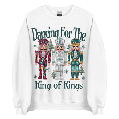 Woman wearing Dancing for the King of Kings Christian Christmas sweater with three colorful nutcracker figures.