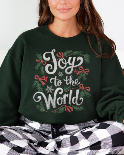 Woman wearing dark green Joy to the World Christian Christmas sweater with pine, bows, and snowflake design.