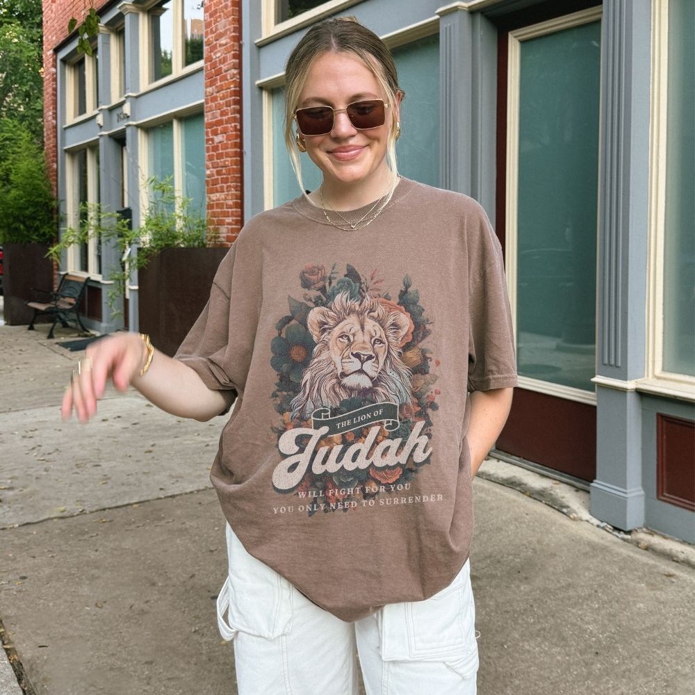 Woman wearing a Lion of Judah Christian t-shirt artwork with lion illustration and scripture text