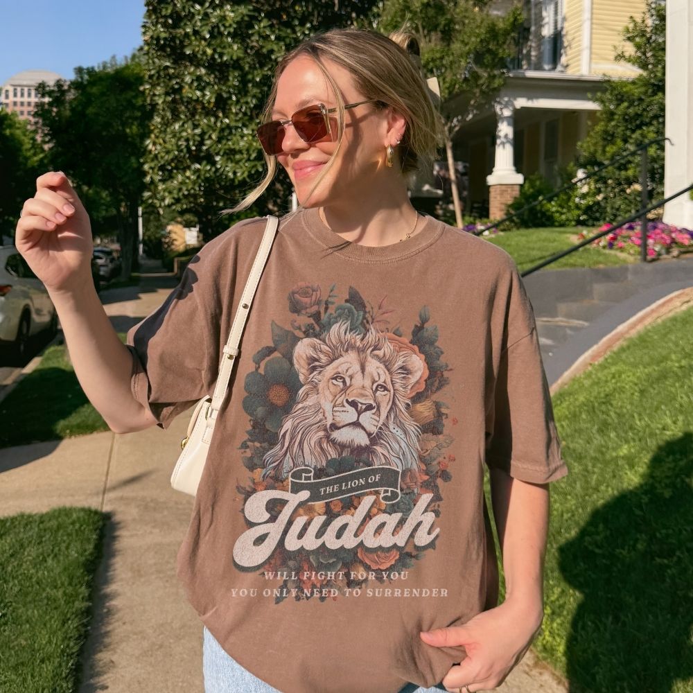 Woman wearing a Lion of Judah Christian t-shirt artwork with lion illustration and scripture text