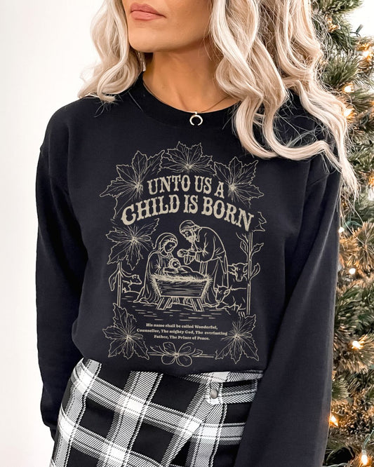 Woman wearing black Unto Us a Child Is Born Christian Christmas sweater with nativity scene and poinsettia design.